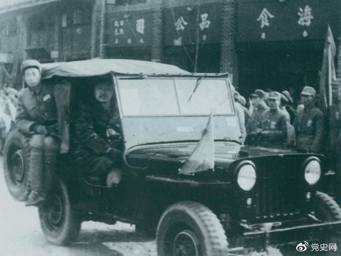 1949年12月30日,人民解放军在成都举行入城式。图为贺龙乘吉普车进入成都。